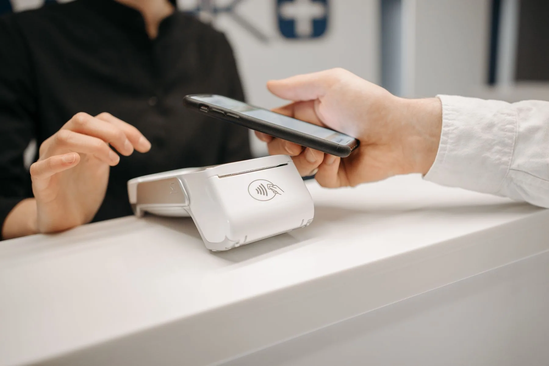 A smartphone held above an unbranded contactless payment terminal